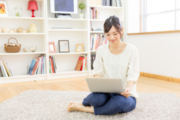 attractive asian woman using laptop in the living room