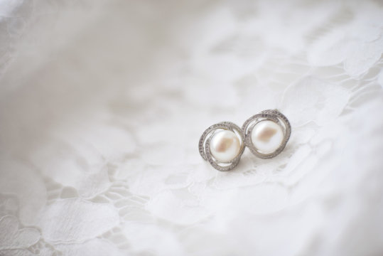 bride earrings lay on the dress