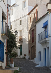 Fototapeta na wymiar narrow street with white houses in historical center of Cadaques, spain