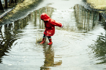 .Boy splashing in puddle