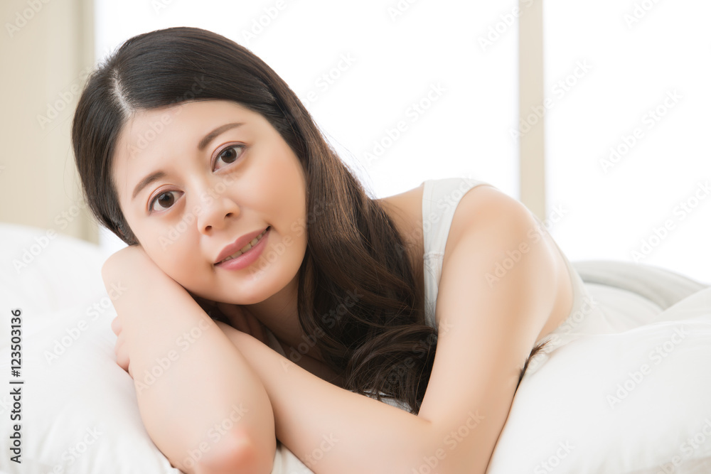 Wall mural beautiful Asian young woman lying on bed comfortably and blissfu