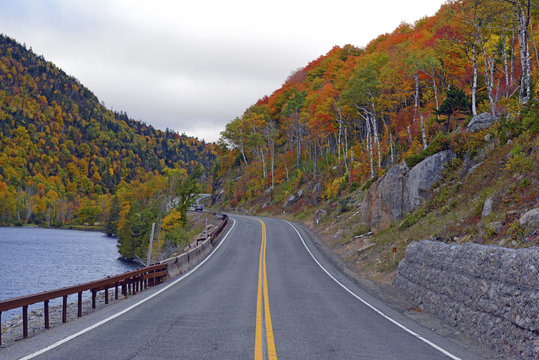 Driving into the mountains with Autumn foliage with red, orange and yellow fall colors in A Northeast forest