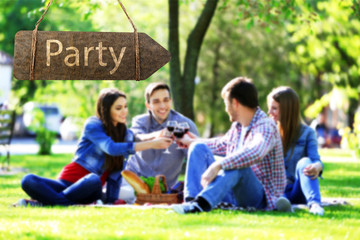 Wooden sign arrow with text PARTY on blurred people background