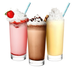 Glasses with delicious milk shakes on white background.