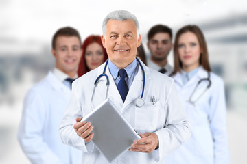 Doctor and medical team on blurred hospital background. Health care concept.