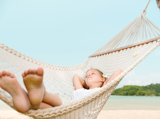 girl slipping in hammock on the beach