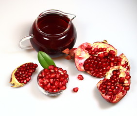 гранат в тарелке с зеленым листом и гранатовым соком