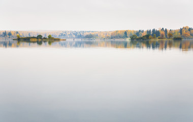 Fog on the lake Senezh in Solnechnogorsk fall in calm weather. Views of the picturesque islands and a pedestrian bridge. Autumn water landscape