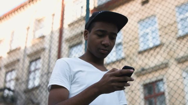 attractive, black guy uses a smartphone