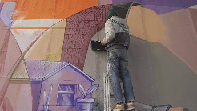 graffiti artist painting on the wall, slow motion
