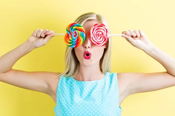 Zelfklevend Fotobehang Young woman holding lollipops © Tierney