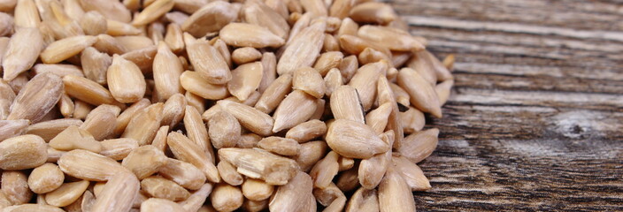 Heap of sunflower seeds on wooden background