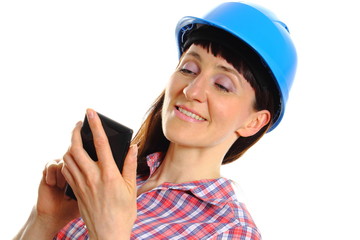 Builder woman in protective helmet using mobile phone