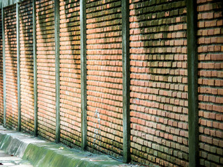 ancient brick wall beside way after rain fall