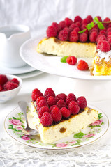 Cheesecake, souffle, cream mousse, pudding dessert with fresh raspberries and mint leaves on a white plate