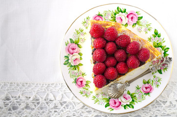 Cheesecake, souffle, cream mousse, pudding dessert with fresh raspberries and mint leaves on a white plate