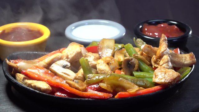 Black seramic lava Mexican Fajita guvec plate rotating with hot smoke steaming
