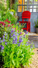 Fototapeta na wymiar Relaxing area in cozy garden./ Relaxing area with red chair in cozy garden. 