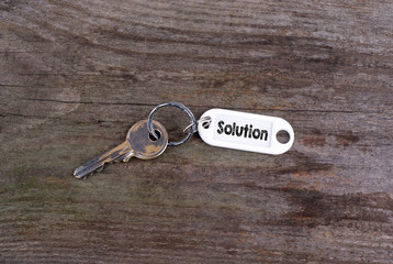 Old key With Solution Text. Wooden texture background