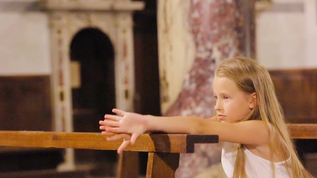 Little cute girl praing in the church