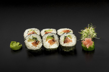 small set fresh sushi rolls decorated with seaweed salad and was