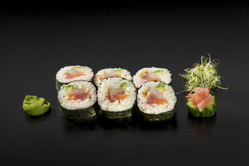 small set sushi rolls decorated with seaweed salad and wasabi