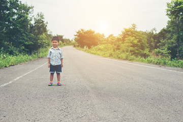 The boy stood on the street and smiling at the camera with a fre