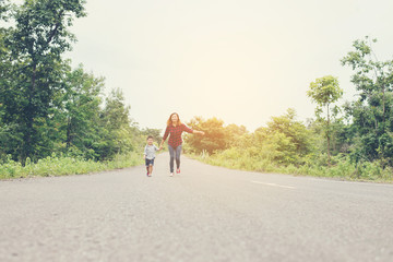 Obraz premium Little boy holding his mother hand running on the street enjoy g