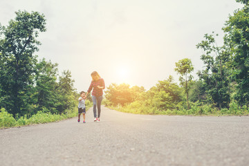 Obraz premium Little boy holding his mother hand running on the street enjoy g