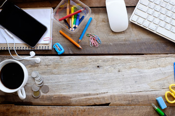 bove view of office supplies and gadgets on a wooden desk backgr