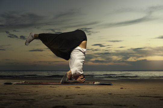 Young Tattoo Man Practicing Head Stand Yoga Pose