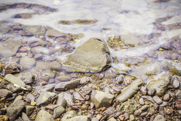 Stones and water surface in the riverside.
