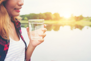 Young beautiful hipster woman Holding water standing on pier, re