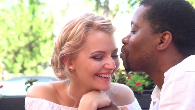 happy young multiethnic couple smiling and kissing