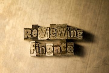 Reviewing finance - letterpress text sign