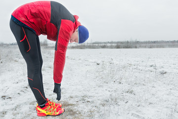 Sportsman making winter training session at snowy field background outdoors