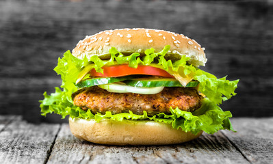 Homemade cheeseburger with vegetables, hamburger bun, closeup