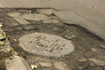 Road destroyed after winter. A hole in the road.