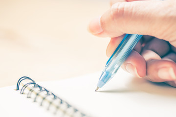 Business women hands working writing notebook on wooden desk, lighing effect