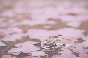 wedding rings on a wooden background with confetti Vintage Retro