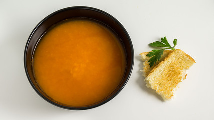 red lentil soup in black dish and toast , top view