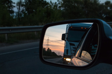Road reflected in car mirror on a summer day