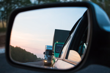 Road reflected in car mirror on a summer day