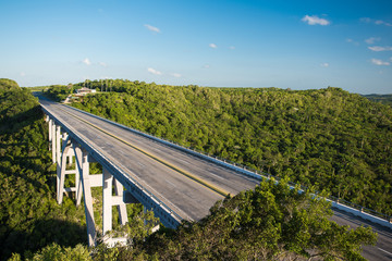 Panoramic view of the big wide deserted empty bridge through the valley of the tropical jungle in hot sunny summer day at province Matanzas