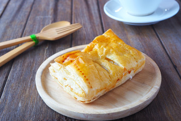 Close up of apple cinnamon puff pastry on a wooden plate.