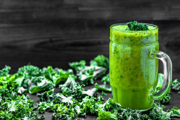 Jar of smoothie with green vegetables, leaves of kale in a glass