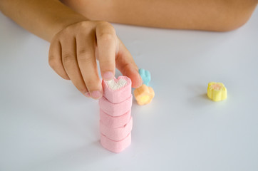 Obraz na płótnie Canvas Child hands play jellys on white table