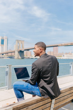 Young Black Businessman Working With the Laptop in Front of the Manhattan Skyline