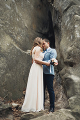 Happy wedding couple kissing and hugging near a high cliff
