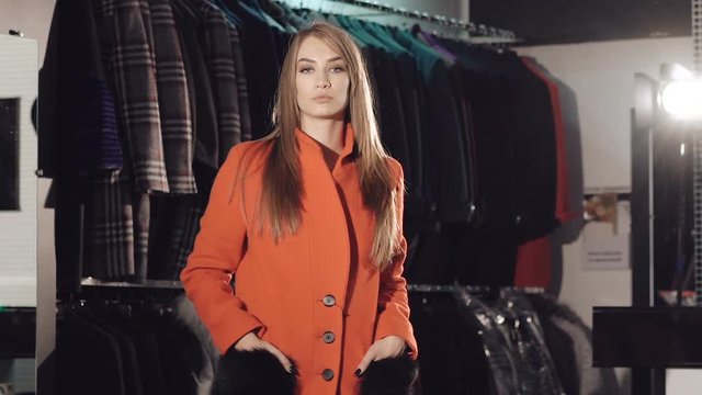 Rich lady catwalking in red fur coats in the rich boutique. Slowly